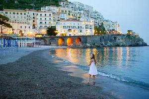 förtjusande liten flicka på solnedgång i amalfi stad i Italien foto