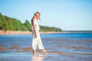 bedårande liten flicka på stranden under sommarlovet foto