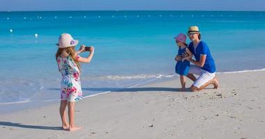 lycklig familj med tre njuter av strandsemester foto