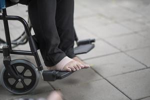 närbild av en äldre person i rullstol med smärtsam fot