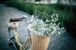 vintage cykel med en korg full av vilda blommor foto