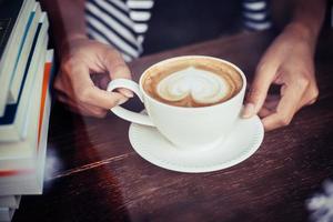 kvinnans händer som kopplar av med kaffe på kaféet foto