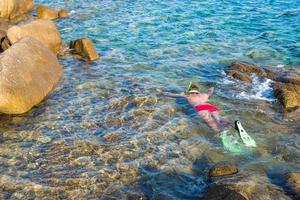 ung man snorkling i klar tropisk turkos vattnen foto