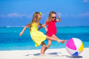 liten förtjusande flickor spelar på strand med luft boll foto