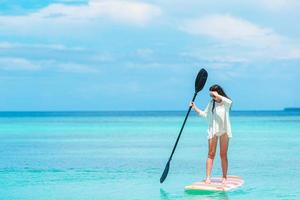 aktiv ung kvinna på stand up paddle board foto