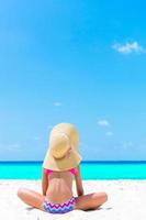 förtjusande liten flicka på strand under sommar semester. tillbaka se av unge på de havsstrand foto