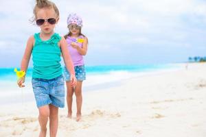 liten förtjusande flickor på vit tropisk strand foto