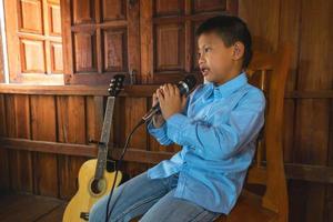 pojke som sjunger bredvid en gitarr foto
