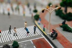 närbild av miniatyrfolk som sitter i stolar i parken foto