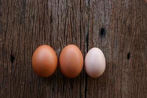 tre ägg på ett träbord foto
