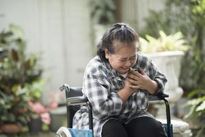 äldre kvinna med hjärtsjukdom som sitter i rullstol