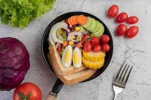 grönsaksallad med bröd och kokta ägg foto