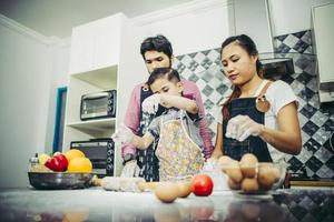 lycklig familj njuter av sin tid att laga mat tillsammans i köket foto