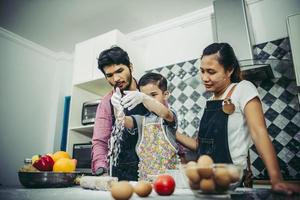 lycklig familj njuter av sin tid att laga mat tillsammans i köket foto