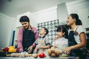 lycklig familj njuter av sin tid att laga mat tillsammans i köket foto