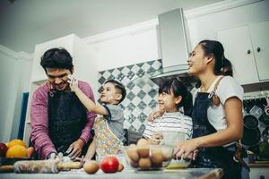 lycklig familj njuter av sin tid att laga mat tillsammans i köket foto