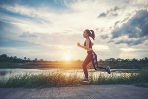 en ung glad kvinnlig löpare som joggar utomhus foto