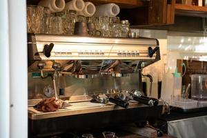 automatisk kaffe maskin med bottenlös portafilter och glas i kaffe affär foto