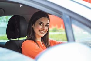 söt ung lady Lycklig körning bil. bild av skön ung kvinna körning en bil och leende. porträtt av Lycklig kvinna förare styrning bil med säkerhet bälte på foto