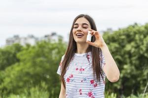 kvinna gäller nasal spray. ung kvinna använder sig av näsa spray för henne pollen och gräs allergier allergi lättnad blommande träd i bakgrund. vår säsong- allergier och hälsa problem. foto