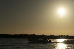 motor båt silhuett på solnedgång i hav foto