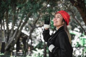 porträtt av Lycklig asiatisk ung kvinna i vinter- kostym på de skog med kopia Plats foto