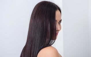skön ung kvinna med lång svart hår i en skönhet salong. foto