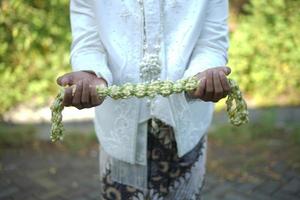 brudgum innehav jasmin och magnolia blomma halsband foto