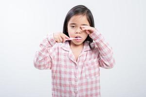 liten flicka Asien pensling tänder lyckligt vit bakgrund foto