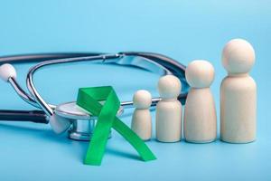 grön band och stetoskop.behandling begrepp för äggstockar cancer och cervical cancer. foto