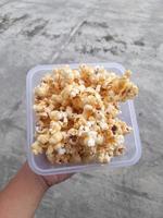 en låda av popcorn varelse hölls utomhus under de dag foto