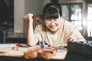 ung vuxen asiatisk kvinna njuter roll spelar bordsskiva berättande och styrelse spel med miniatyrer foto