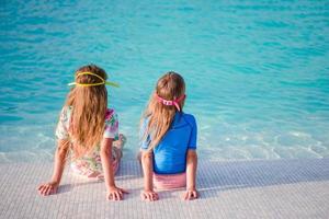 förtjusande liten flickor i utomhus- simning slå samman foto