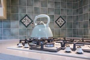 vattenkokare på gas spis i modern kök foto