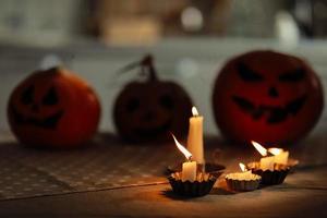 ljus är brinnande på de tabell. halloween pumpa lykta med skrämmande ansikte på bakgrund. familj framställning Allt hallows eve halloween fest dekorationer. bakgrund, kopia Plats. selektiv fokus foto