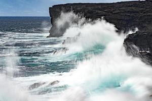 hav i storm brytning vågor på lava sten klippa foto