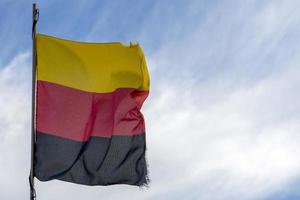 Tyskland flagga vinka på blå himmel foto