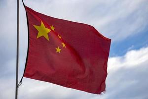 vinka kinesisk flagga röd bakgrund och gul stjärnor foto