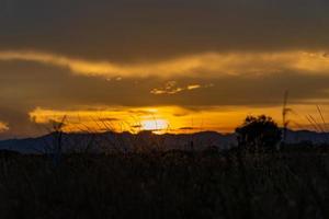 senset ögonblick se Bakom de berg i de gyllene ljus från de Sol. foto