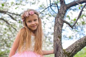 Lycklig liten förtjusande flicka i blomstrande äpple träd trädgård foto