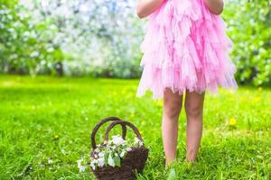 förtjusande liten flicka i blomstrande äpple träd trädgård foto