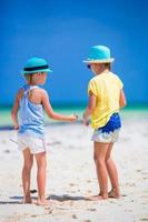 bedårande små flickor på stranden under sommarlovet foto