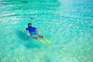 ung man snorkling i klar tropisk turkos vattnen foto