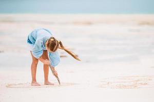 bedårande aktiv liten flicka på stranden under sommarlovet foto