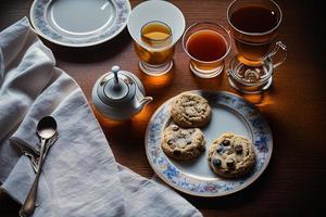 fotografi av en tallrik av småkakor och en glas av te på en tabell med en trasa och en servett på den foto