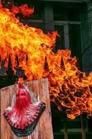de symbol av en medeltida bödel på en bakgrund av puffar av orange brand. collage. brand. brinnande flamma och bödel. foto