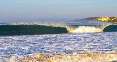 ytterst enorm stor surfare vågor på strand puerto escondido Mexiko. foto