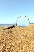 förstorande glas i de sand foto