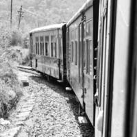 leksak tåg rör på sig på berg backe, skön se, ett sida fjäll, ett sida dal rör på sig på järnväg till de kulle, bland grön naturlig skog. leksak tåg från kalka till shimla i Indien foto