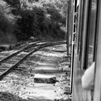 leksak tåg rör på sig på berg backe, skön se, ett sida fjäll, ett sida dal rör på sig på järnväg till de kulle, bland grön naturlig skog. leksak tåg från kalka till shimla i Indien foto